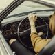Imagem de uma mulher ao volante de um belo automóvel antigo Interatividade Corretora de Seguros