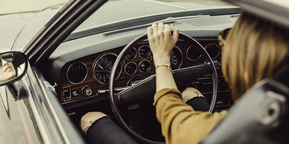 Imagem de uma mulher ao volante de um belo automóvel antigo Interatividade Corretora de Seguros